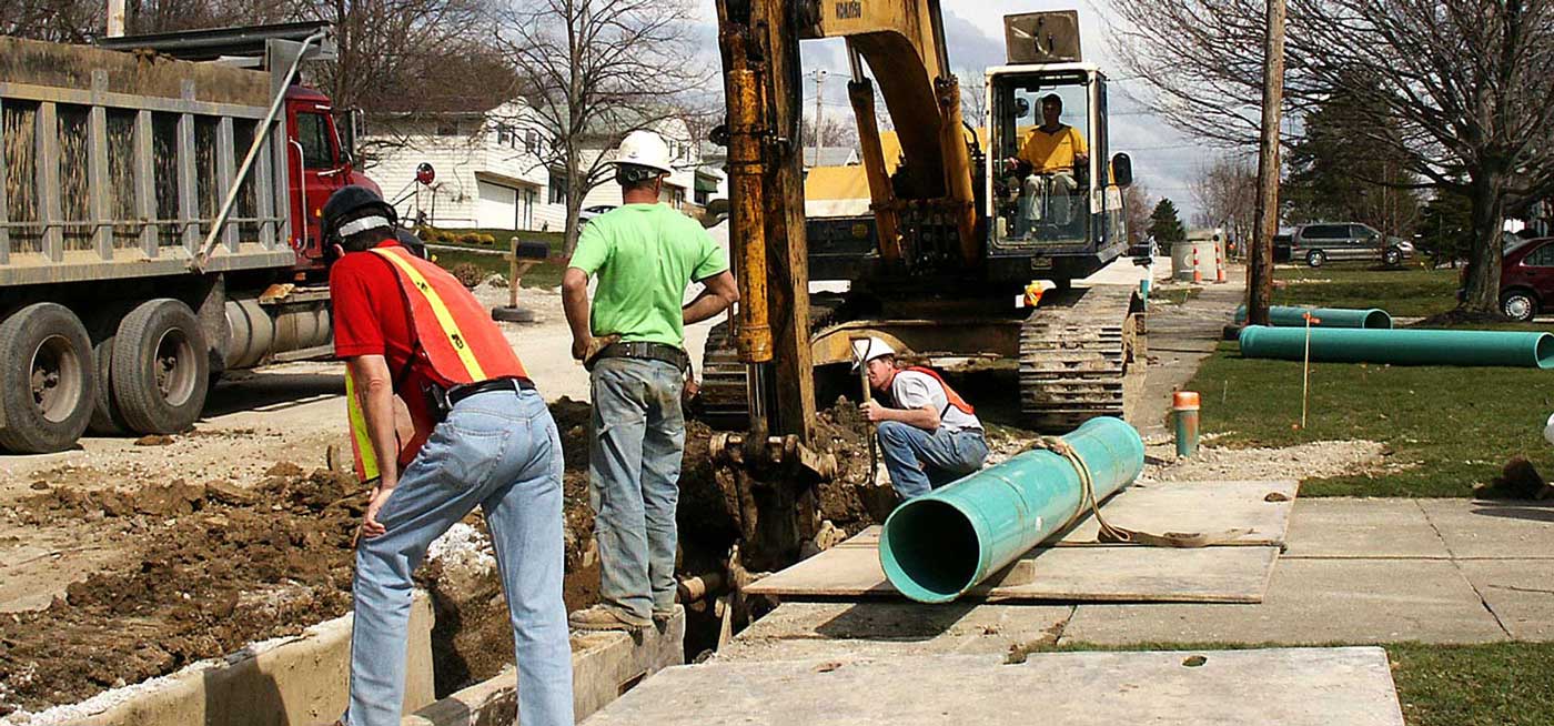 Field team completes work on a job site wearing hardhats and safety vests